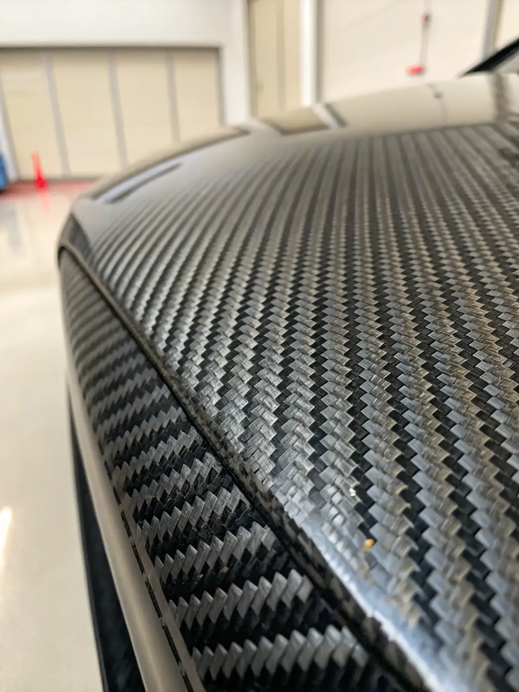 A close-up shot of a carbon fiber composite material being tested for tensile strength in a lab setting, showcasing Neoforge LLC's expertise in material analysis.