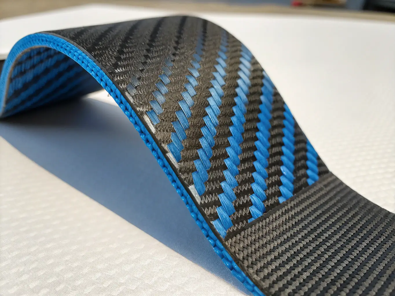 A detailed CAD rendering of a carbon fiber composite structure, highlighting its intricate design and lightweight properties, set against a backdrop of engineering schematics.